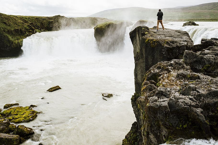 person standing rock formation near body of water, iceland HD wallpaper