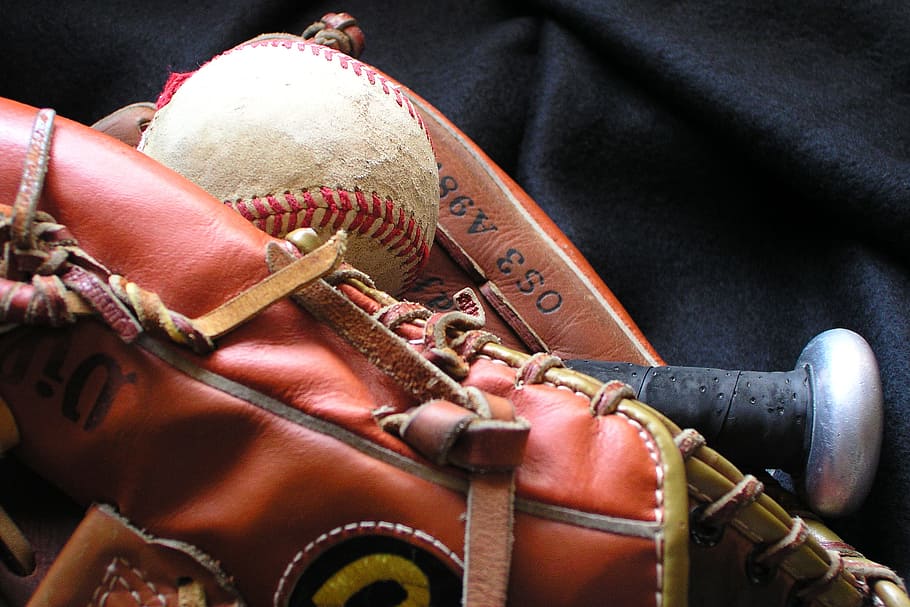 brown Rawlings leather baseball mitt with baseball bat and ball