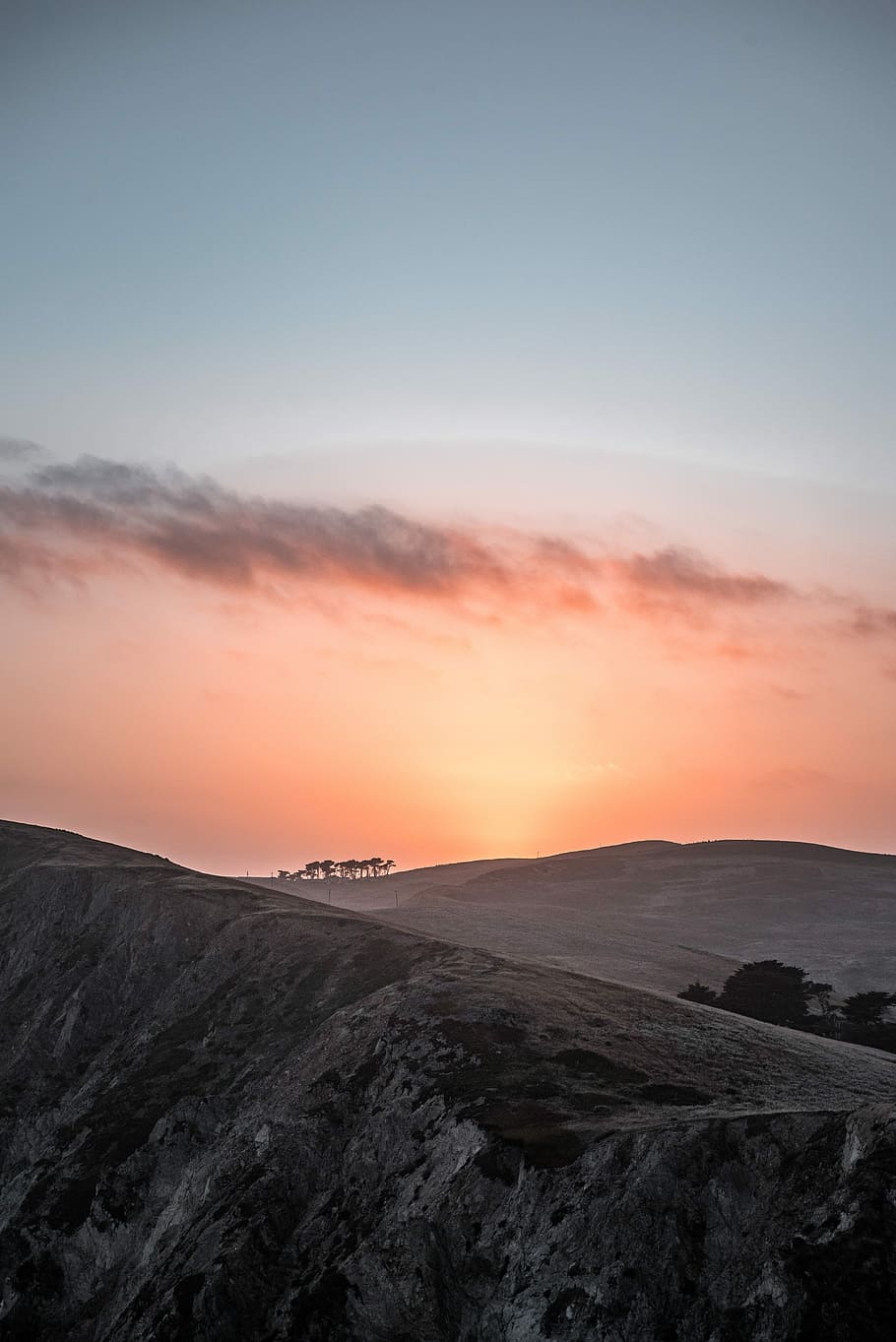 silhouette of leafed trees on mountain covered with snow during orange sunset, gray hills during sunset HD wallpaper