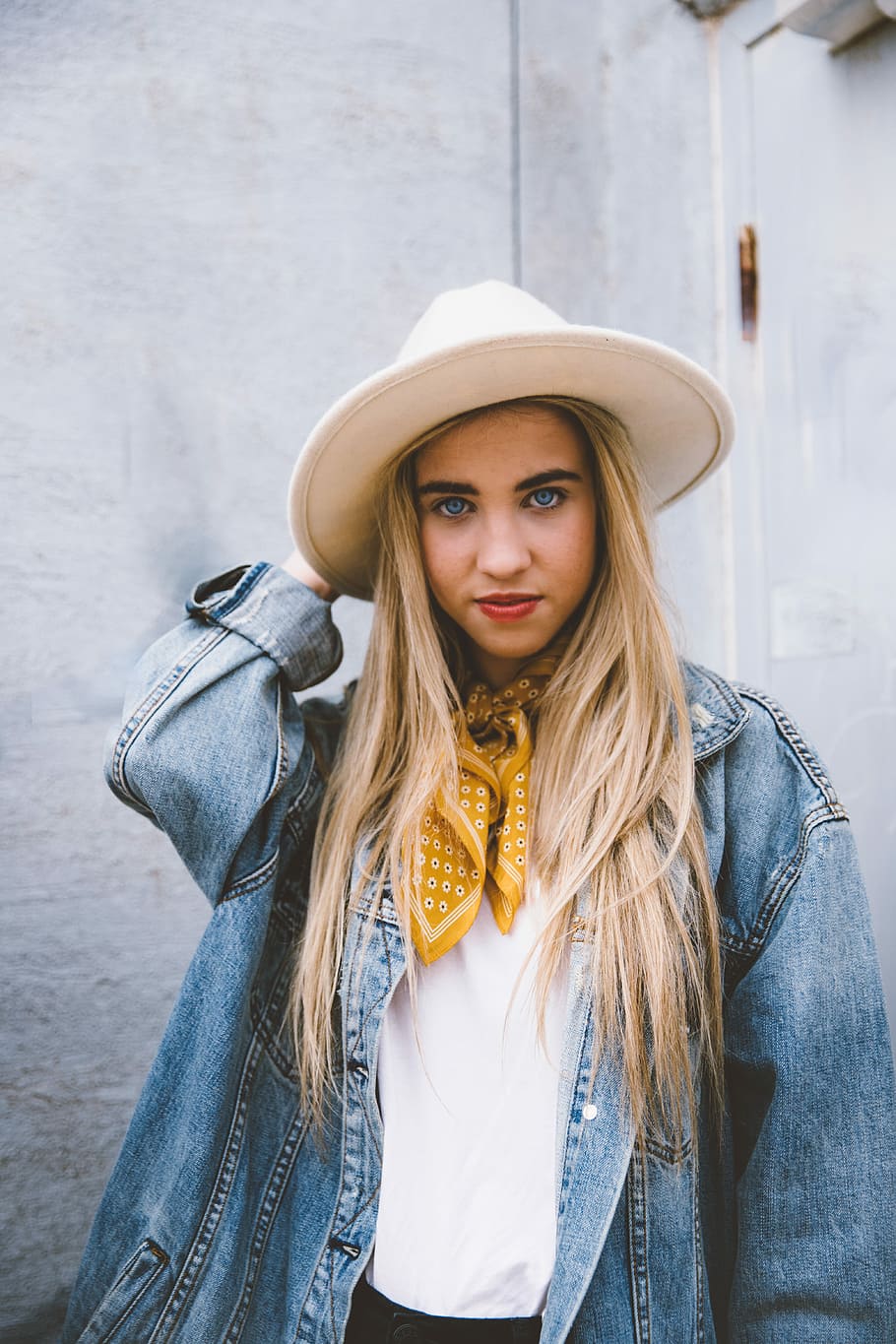 woman wearing blue denim jacket and white hat, woman wearing blue denim jacket and white hat standing near white concrete wall HD wallpaper