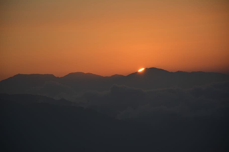 sun setting behind mountain ranges, silhouette of mountain during golden hour HD wallpaper