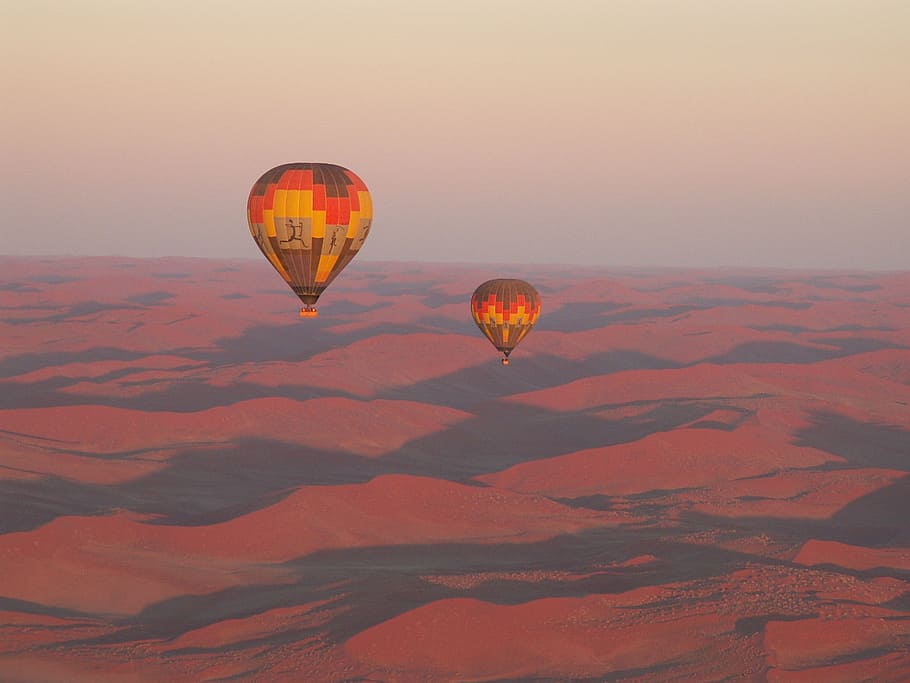 two hot air balloons floating in the sky above desert, travel HD wallpaper