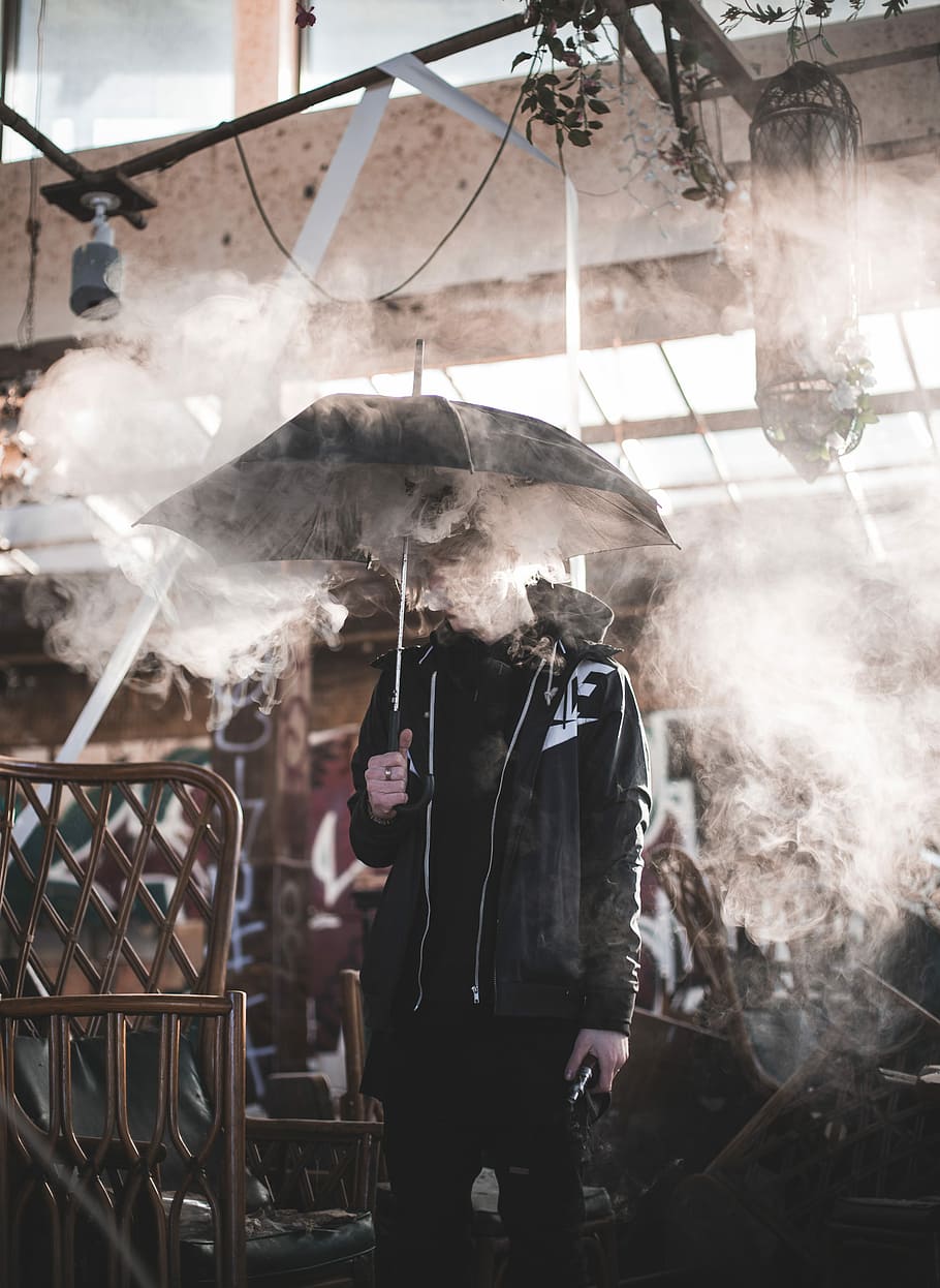 man holding a black umbrella covering him with smoke, man holding umbrella during daytime, HD wallpaper