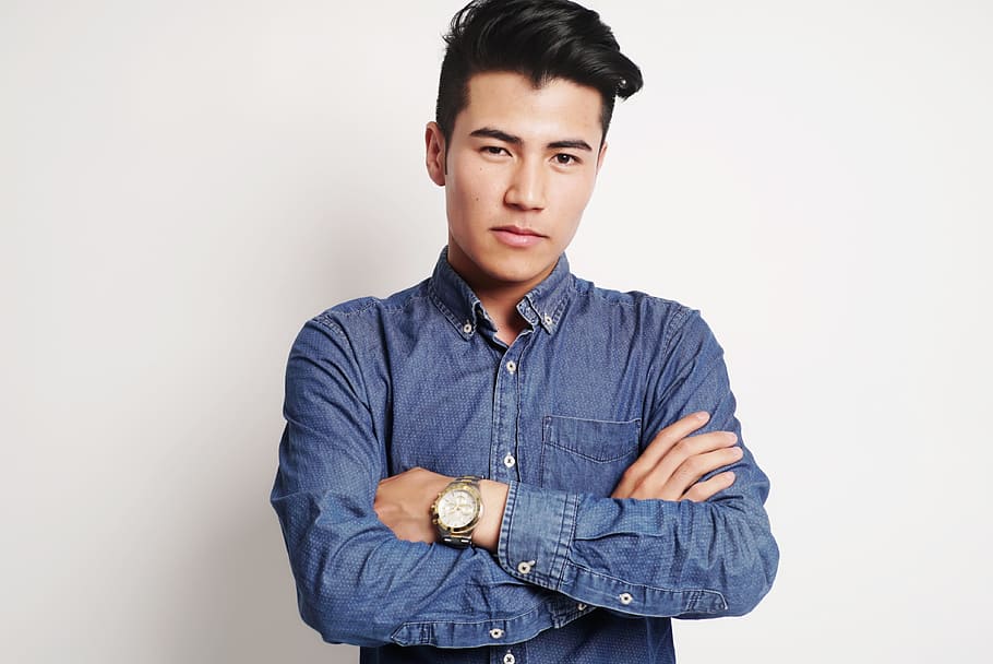 man in blue chambray long-sleeve shirt with gold-colored round watch