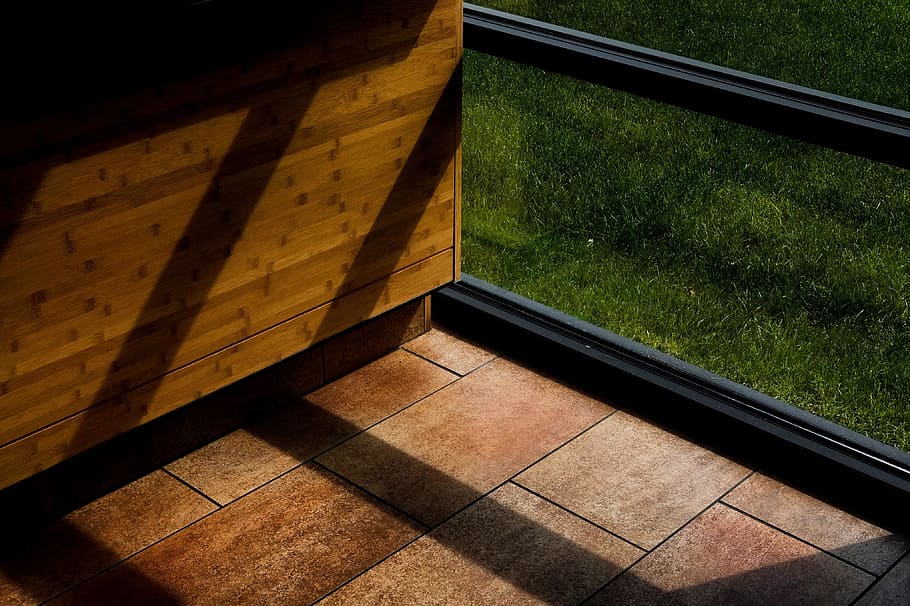 brown wooden box, brown tiled floor beside brown wooden cabinet and black framed glass windw HD wallpaper