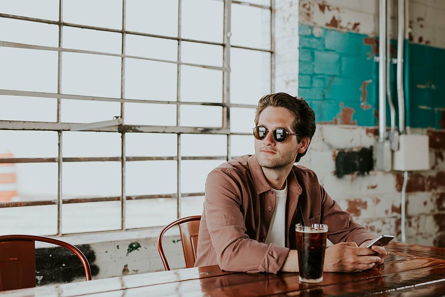 man sitting on chair beside a table with glass of drink, people HD wallpaper