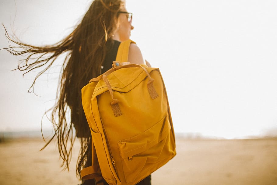 woman carrying yellow backpack, woman wearing black tank top with brown backpack hanged on her right shoulder walking on brown plains photo, HD wallpaper