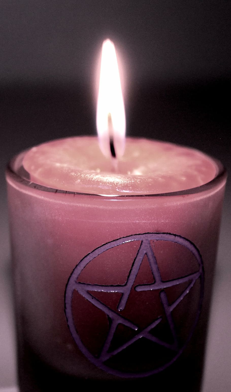 closeup photo of lighted pink votive candle, candle magic, candle magick