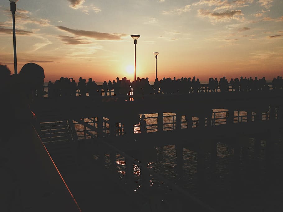 beach, clouds, crowd, dock, evening, lamppost, ocean, people HD wallpaper