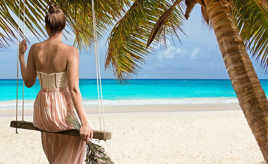woman sitting on swing watching seashore, beach, swing blue, coast