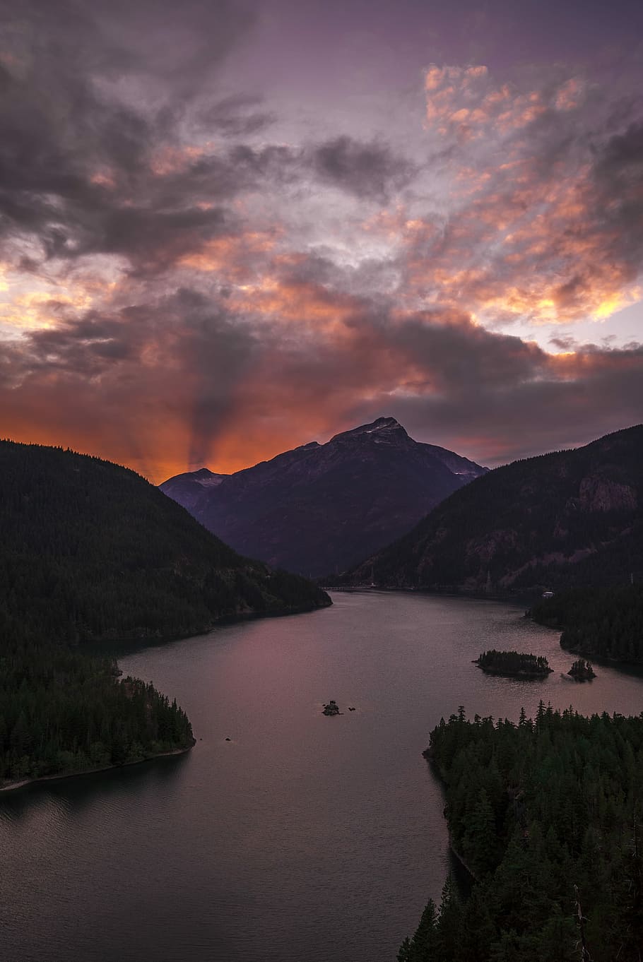 body of water surrounded by mountains during golden hour, body of water between mountain under white and orange cloudy sky HD wallpaper