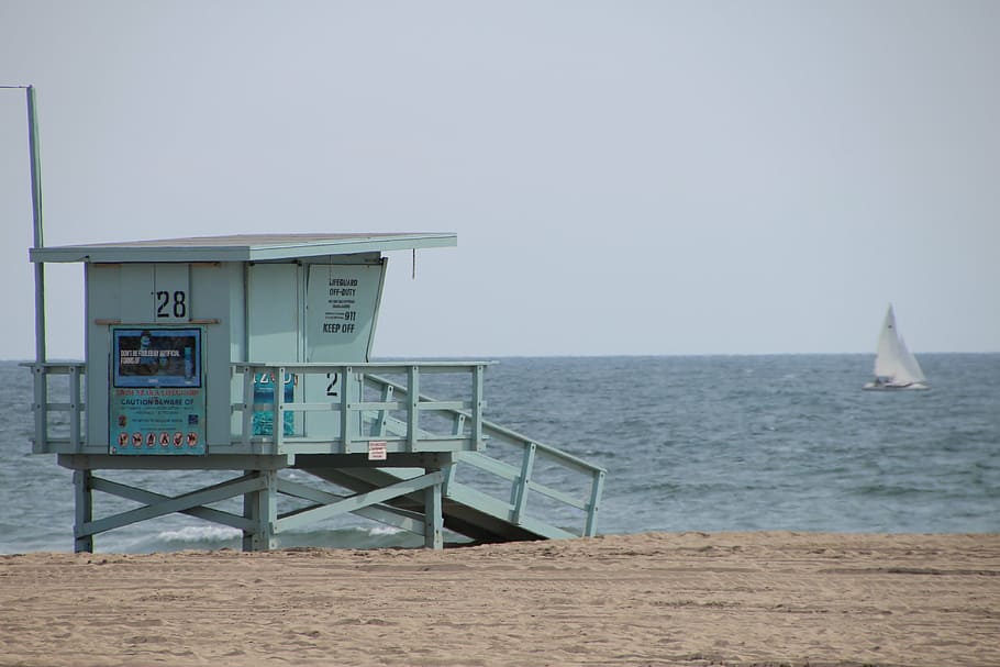 teal wooden lifeguard house on seashore, santa monica, venice beach