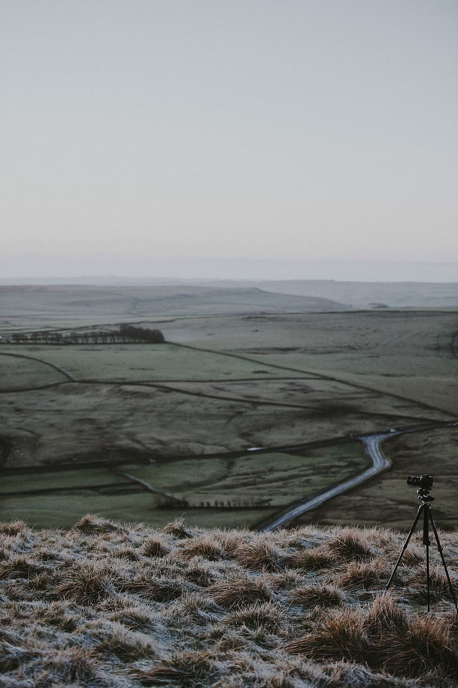 mountain view of field, camera setup on top of the cliff overlooking the road and grass field HD wallpaper