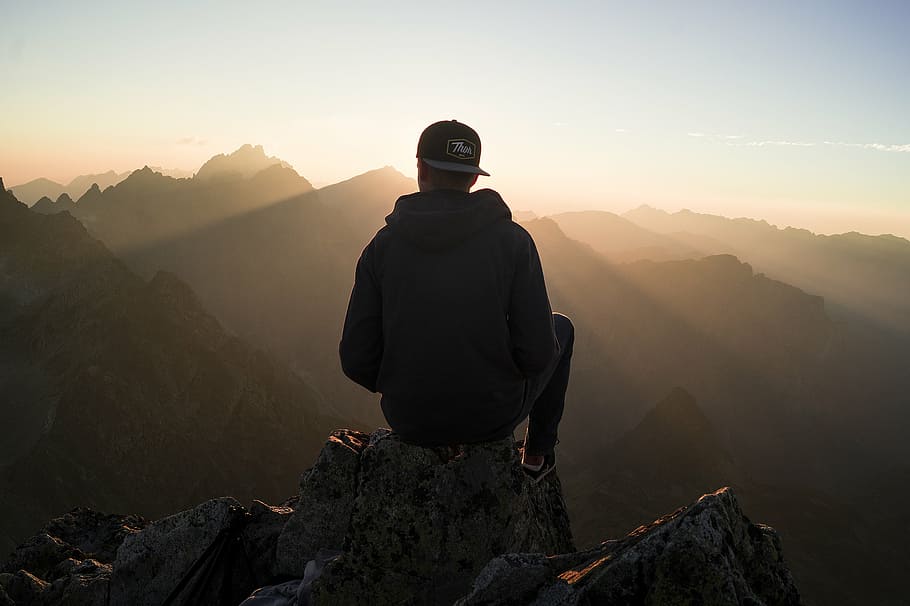 silhouette photography of person sitting on top of mountain, macro