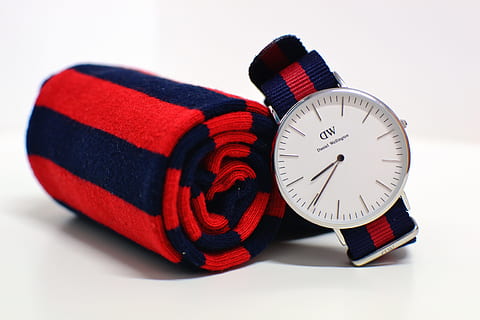 round silver-colored Daniel Wellington analog watch beside red-and-blue striped scarf HD wallpaper