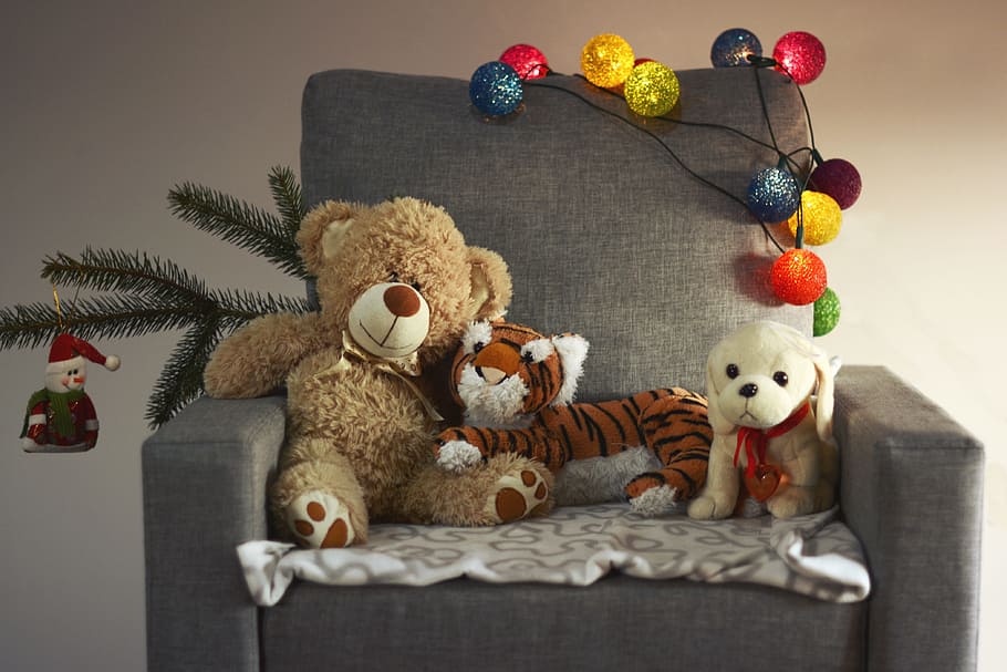brown bear, tiger, and dog plush toys on black sofa chair, armchair