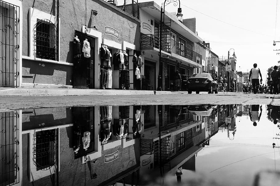 grayscale photo of people walking at the sidewalk, grayscale photography of people near car and houses HD wallpaper