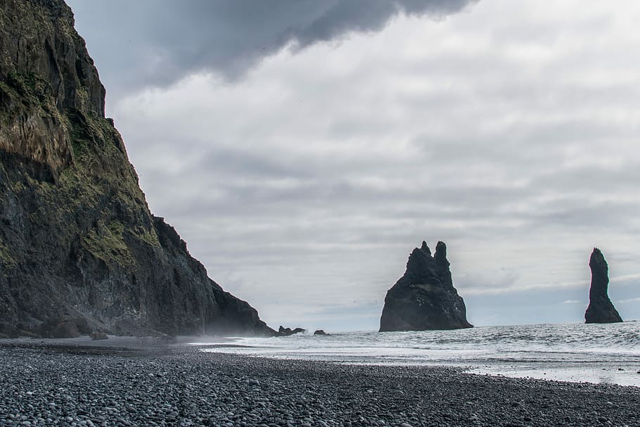 mountain near seashore under gray sky, rocky shore under cloudy sky HD wallpaper