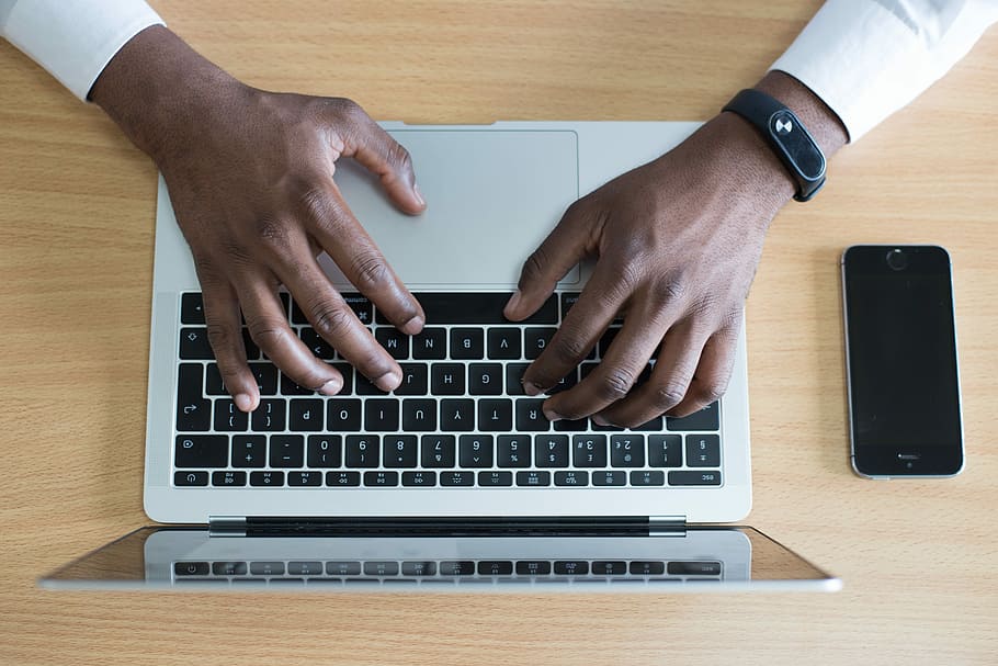 person's hand on MacBook near iPhone flat lay photography, person holding MacBook HD wallpaper