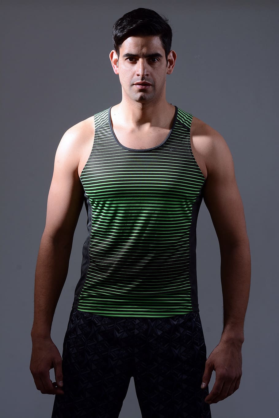 man wearing black and green striped tank top and gray bottoms standing, HD wallpaper