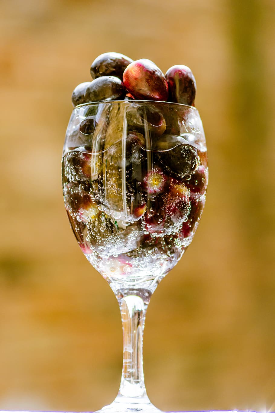 tilt shift lens photography of clear wine glasses, grapes, black