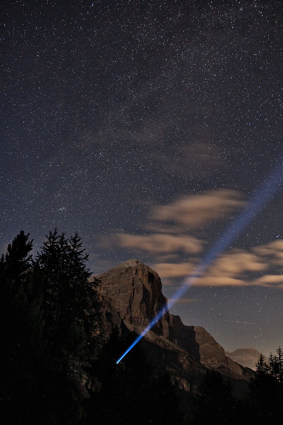 gray rock mountain under starry night, blue light aimed at sky during night HD wallpaper