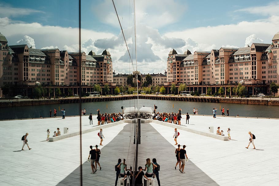 people gathering outside building, group of persons standing near body of water during daytime HD wallpaper