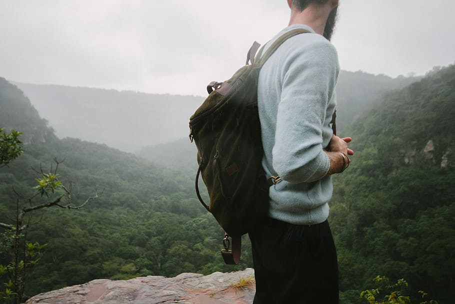 man standing on mountain top during day, man looking at the mountain HD wallpaper