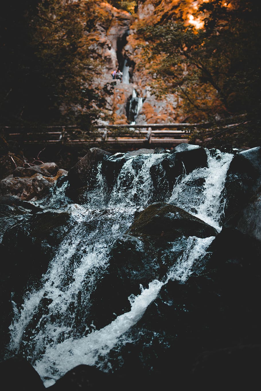 photo of water rushing down through stone, landscape photography of waterfalls beside brown wooden bridge HD wallpaper