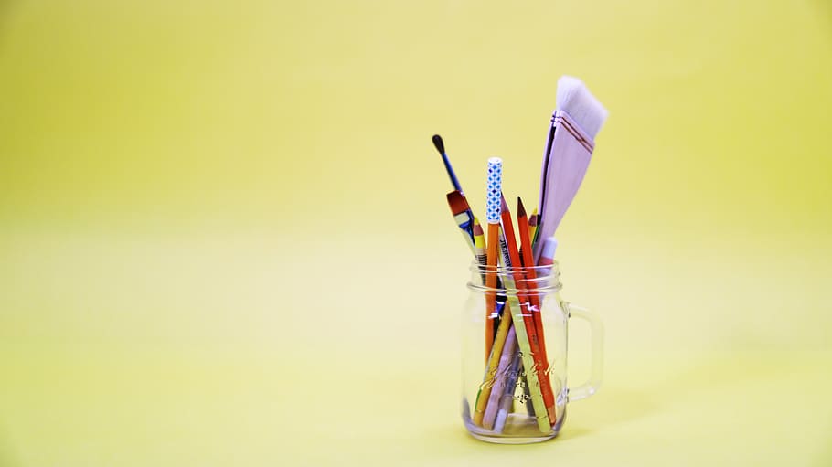 assorted-color pens and pencils in clear glass mason jar, yellow HD wallpaper