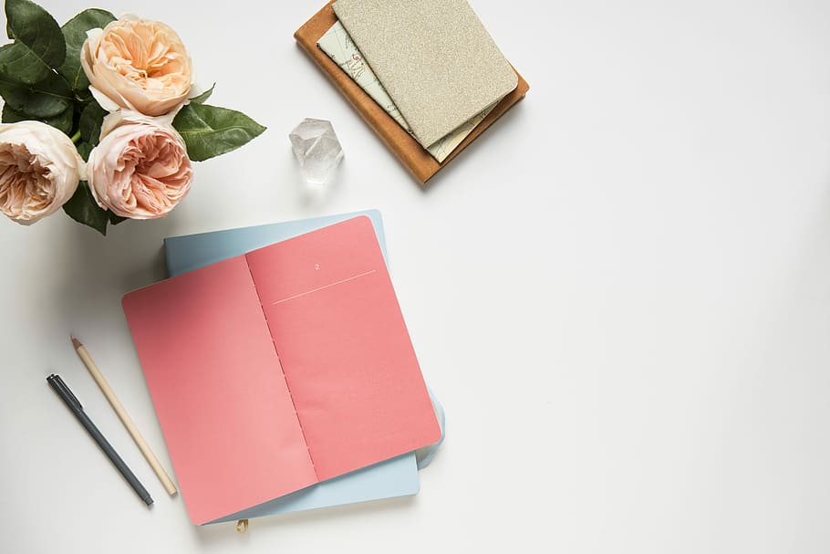 pink covered book in top view photography, flat lay photography of paper and pencil HD wallpaper