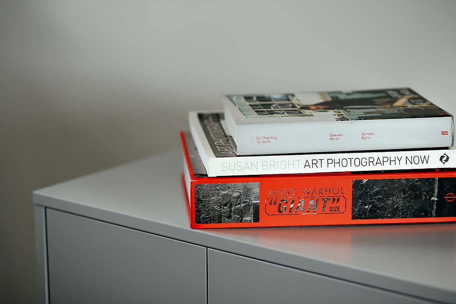 stacked three assorted books on gray wooden surface, three assorted books on gray side board HD wallpaper