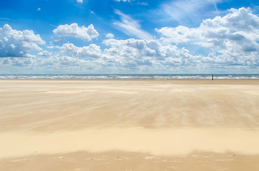 white brown sand near shore under white clouds and blue sky during daytime HD wallpaper