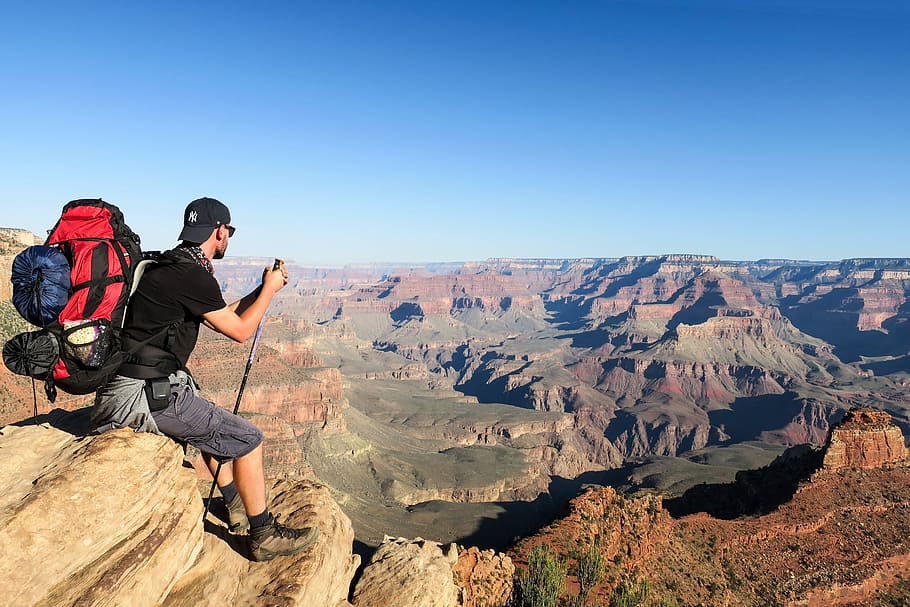 man sitting on mountain rock, backpack, canyons, climbing, scenics - nature HD wallpaper