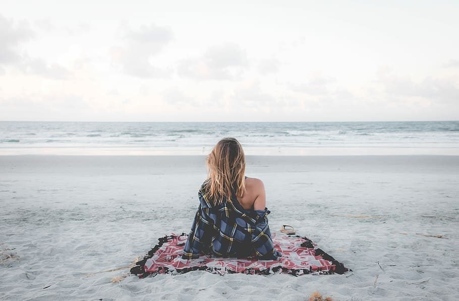 woman sitting on blanket located on shoreline, woman sitting on mat in front of beach HD wallpaper