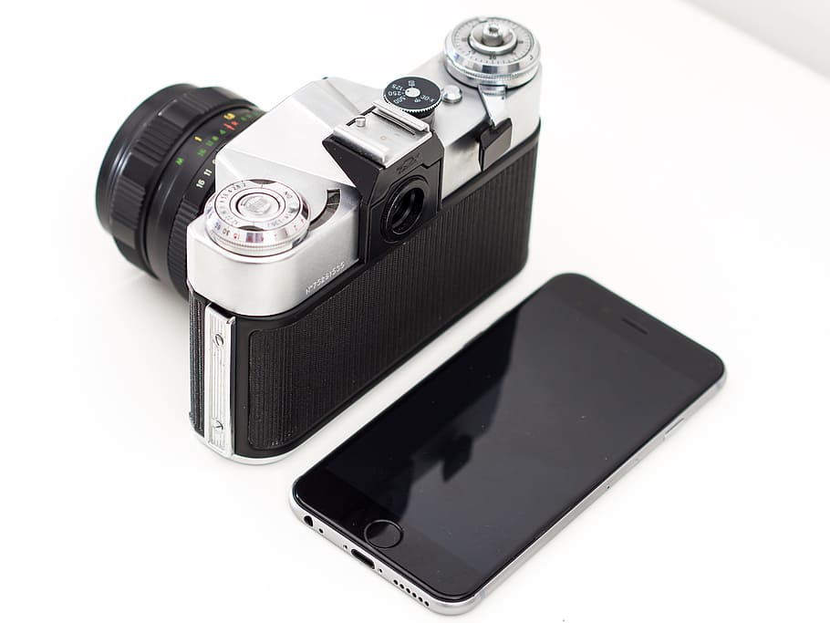black and silver camera and space gray iPhone 6 on table, film camera