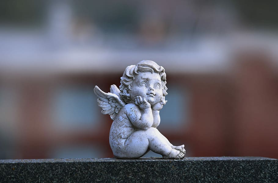 selective focus photography of angel figurine sitting while hands on chin HD wallpaper