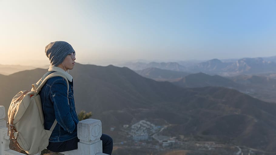 woman sitting on wooden fence overlooking building background of mountain at daytime, man sitting on railing HD wallpaper