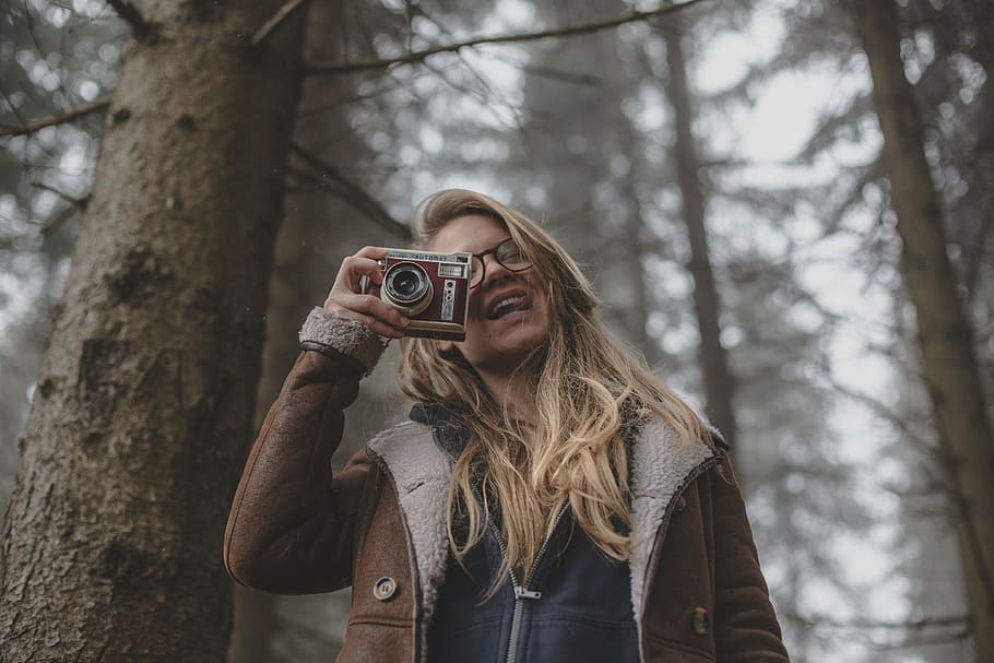 woman holding camera standing beside tree at daytime, people, HD wallpaper