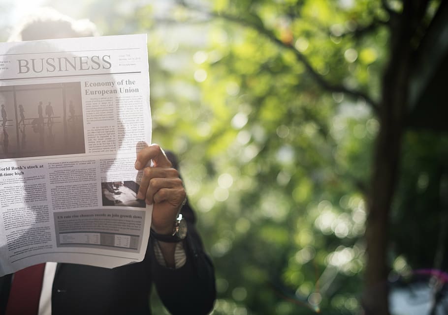 man reading business section of newspaper, business people, businessman