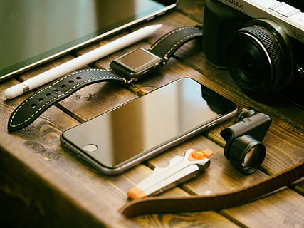 space gray iPhone 6 on brown wooden table, photo of space gray iphone beside clip lens and MILC camera HD wallpaper