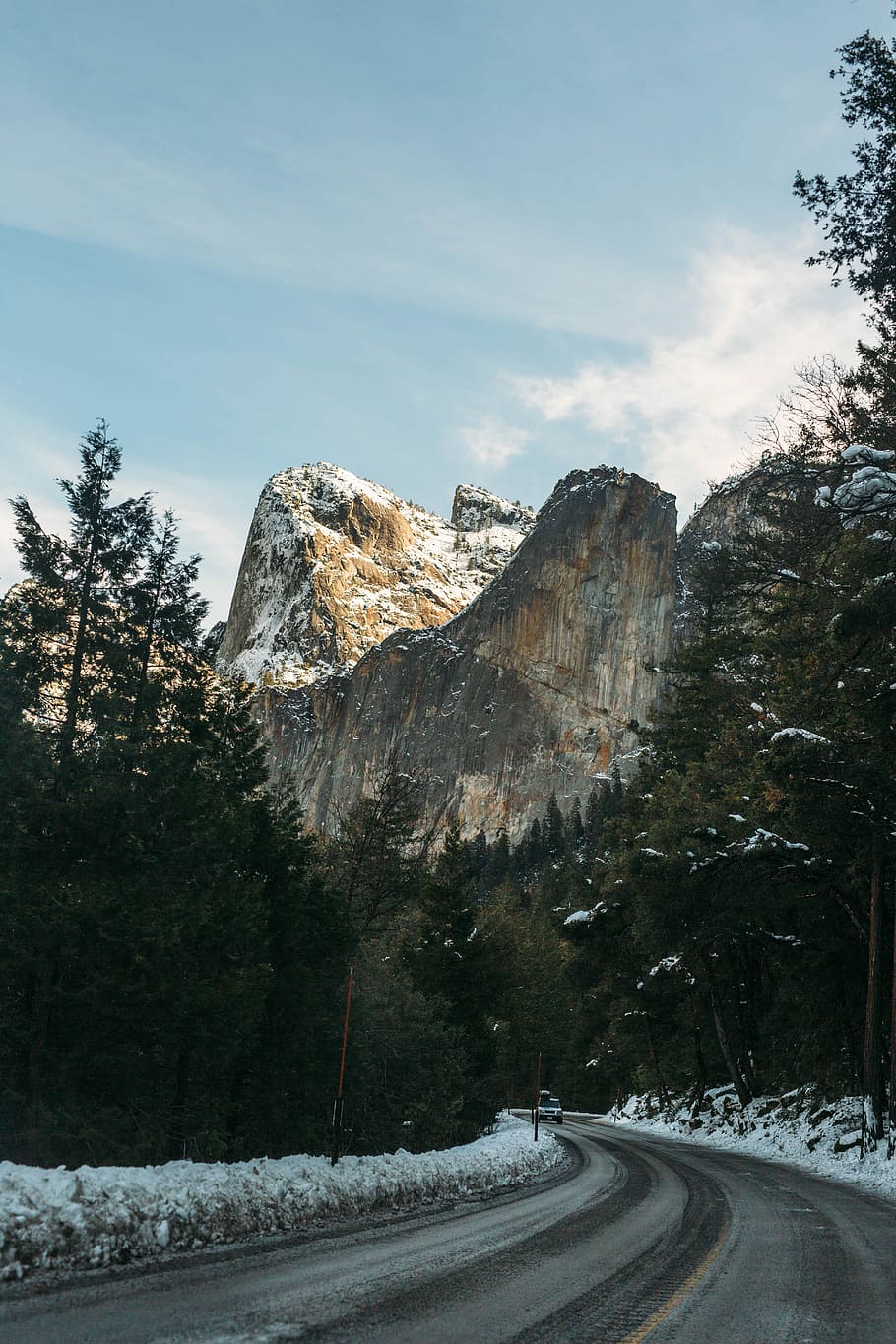 concrete road near rock formation at daytime, photo of a brown snow mountain HD wallpaper