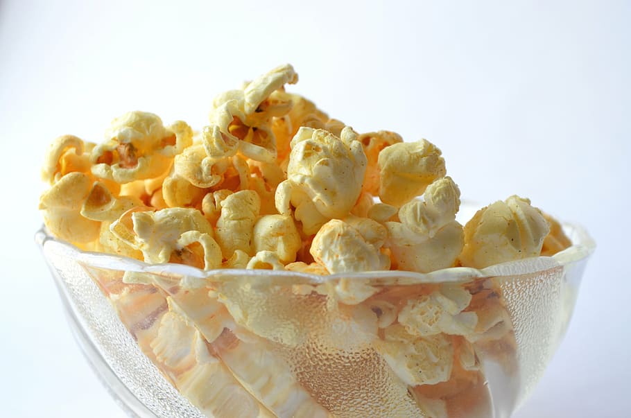 cheese coated popcorn on clear glass bowl, food, snack, yellow