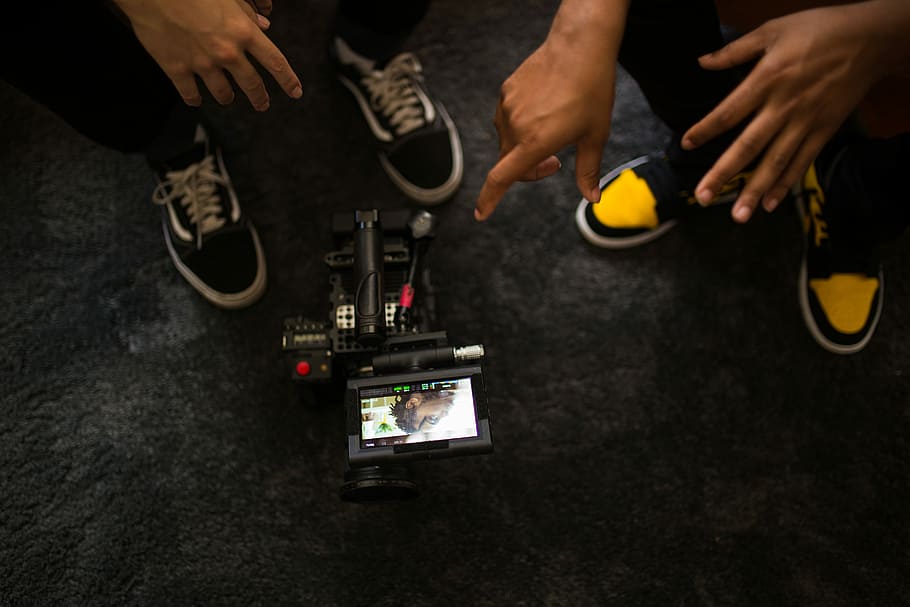 two people looking at video camera, screen, filming, hand, shoes HD wallpaper