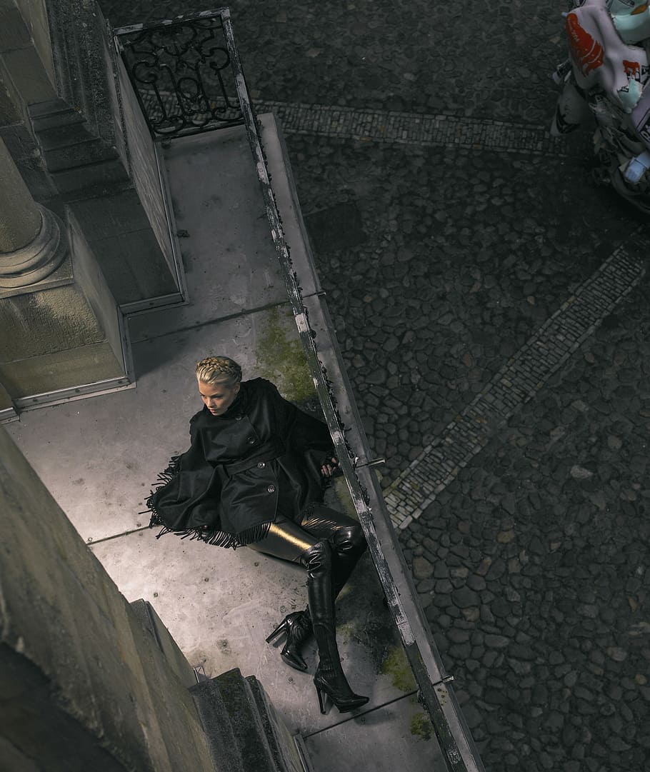 woman posing on ground, woman in black coat lying beside black handrail, HD wallpaper