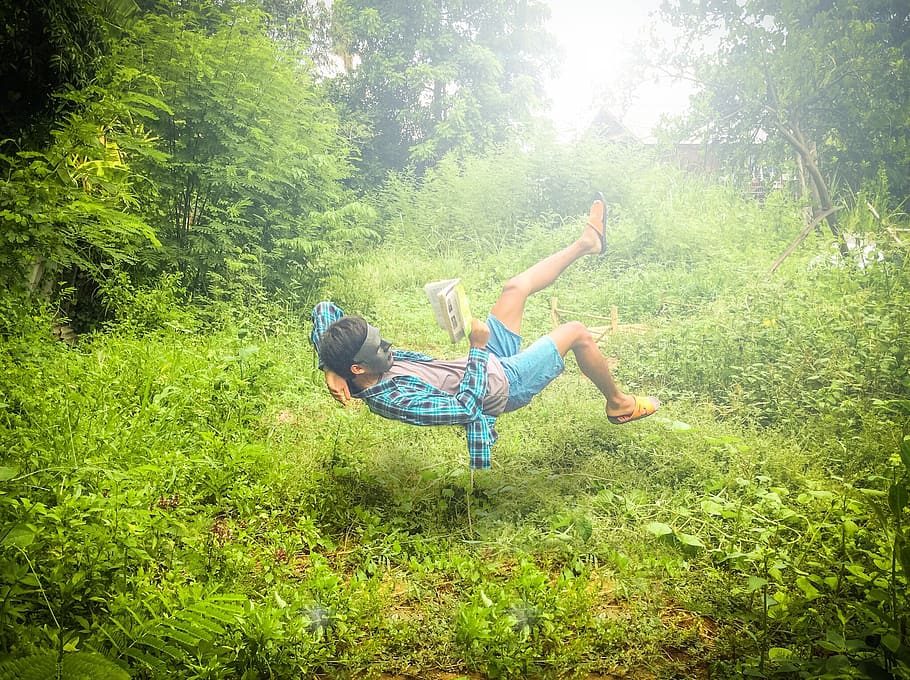 man doing stunt on green grass field, floating, light, feeble HD wallpaper