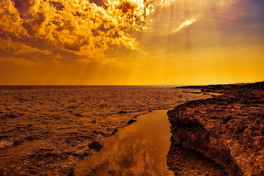 photo of body of water beside cliff during golden hour, sunset HD wallpaper