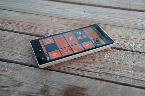 turned-on Windows smartphone on brown wooden surface, lumia HD wallpaper