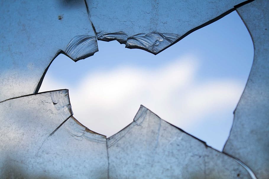 close shot of braked glass, broken window, hole, damage, shattered