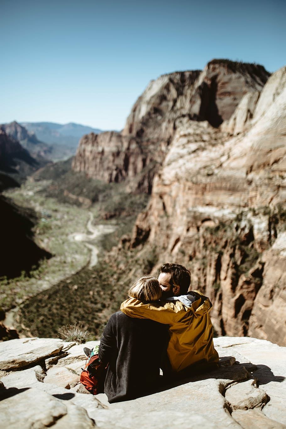 man and woman sitting on mountain cliff during daytime, highland HD wallpaper